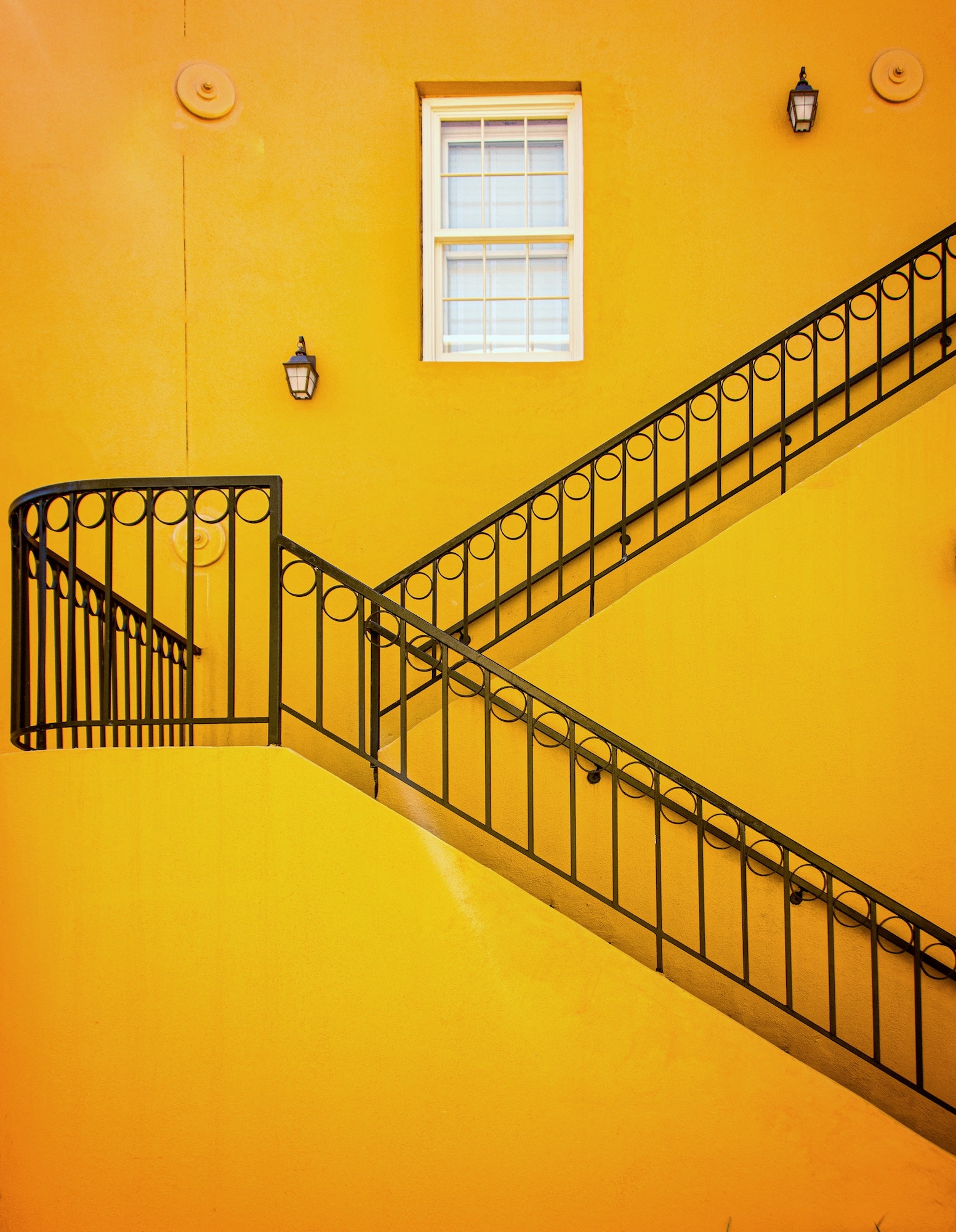 Yellow wall with black iron railing staircase